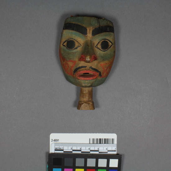 Hearst Museum object 3 of 4 titled Totemic carving, accession number 2-4691, described as Painted wood carving of a human face. Unpainted extension at base; green, red and black.