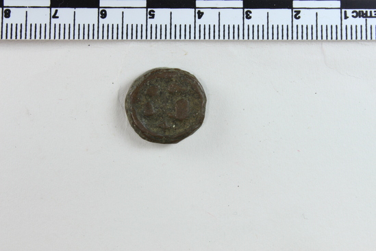 Hearst Museum object 5 of 6 titled Coin: æ 10 nummia (decanummium), accession number 6-23177, described as Obverse: two frontal busts of soldiers or the Emperor and his wife, separated by a cross. Reverse: an I surmounted by a cross potent flanked by Left: [symbol]; Right: [symbol resembling a w] below in ex. [three symbols, the first resembling pi, the last resembling capital N] Denomination: decanummium Size: 1.65 cm Weight: 5.13 g Condition: fair Content: AE Provenience: Naga-ed-Der, Egypt. Hoard of 68 coins (6-23121-88) Mint Date: Alexandria Heraclitus 610-14 A.D. Reference: Warwick Wroth. Byzantine Coins.