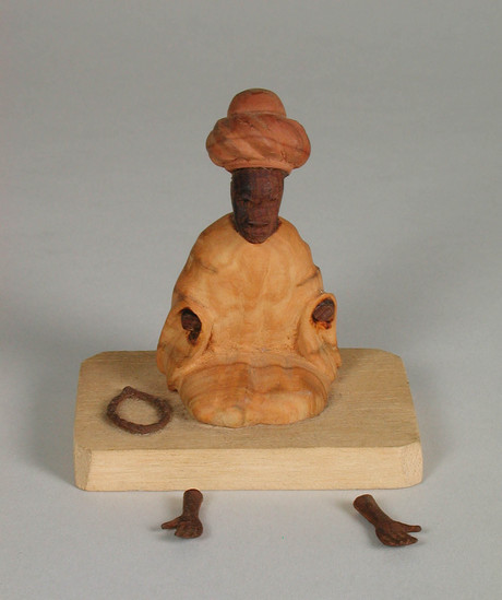 Hearst Museum object titled Thorn carving, accession number 5-15198, described as thorn carving;  Muslim man wearing turban is kneeling on platform, worry beads to his right; arms broken off; ht. 7.7 cm.