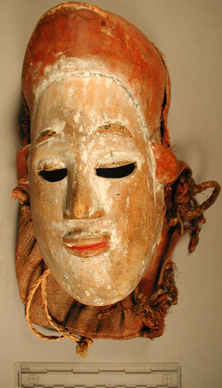 Hearst Museum object titled Mask, accession number 5-16212, described as Ibibo mask (polo player?); carved and painted wood; white skin very worn, red inside ears and mouth. Bback eyebrows, orange/brown cap with bill. canvas drape attached; bracing stitch across lower face.