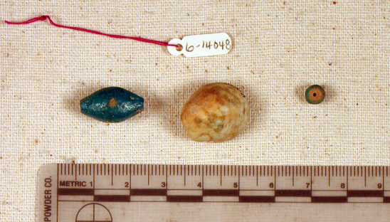 Hearst Museum object titled Beads, accession number 6-14048, described as Beads: 1 blue glaze barrel-shaped, 1 blue glaze spherical, 1 stone fragment, 1 shell fragment. [inv.: 2 faience, 1 shell, original piece count: 4?]