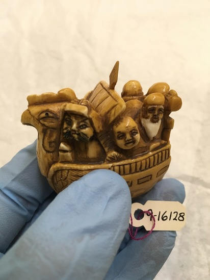 Hearst Museum object titled Netsuke, accession number 9-16128, described as Carving; rooster-shaped boat w/ several individuals within; carved bone (?); w. 4.8 cm.