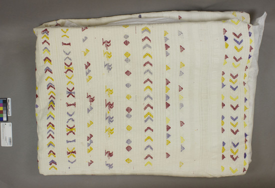 Hearst Museum object titled Huipil, accession number 3-28095, described as Blouse material used as shoulder wrap.  Cotton in bands of heavy and light yarns. Plain weave, brocaded. White ground, yellow, red, purple designs.  Triangle, lozenge motifs.  See Fig. 102b, Textiles of Highland Guatemala. 52 inches by 60 inches