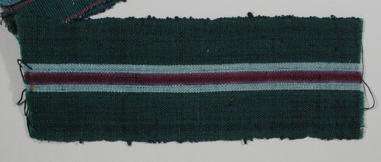 Hearst Museum object titled Textile fragment, accession number 5-11220, described as textile sample (section of narrow band weaving): green side panels; central stripe of maroon flanked with purple and pale blue.