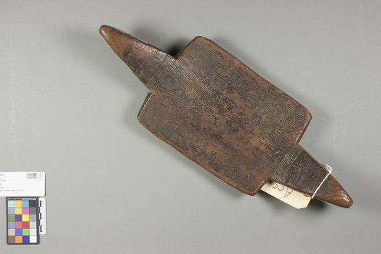 Hearst Museum object titled Board, accession number 5-15237, described as Burden board; carved and incised reddish brown wood, well worn; handles at opposite ends; band of triangles filled with diagonal lines and other geometric designs; depression on underside to fit head