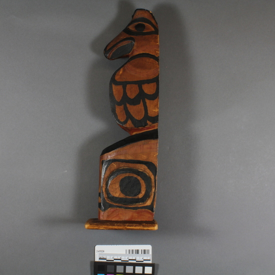 Hearst Museum object 1 of 4 titled Totem pole model, accession number 2-41024, described as Wooden totem pole model, carved and painted, on wooden base; upper half, which probably represents a raven, has carved head, black-painted details. Old label says "Kitkatlah, B.C.".