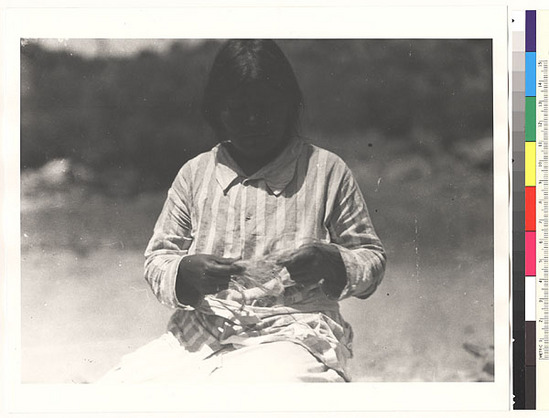 Hearst Museum object titled Black-and-white negative, accession number 15-6235, described as Mollie Cheepo separating milkweed fiber with fingers after combing it out with a stick, Tasineu