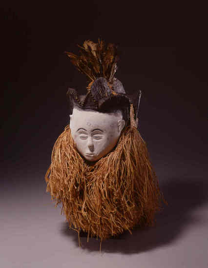 Hearst Museum object titled Mask, accession number 5-1786, described as Mask of two faces with feather headdress (ngu ebibi or nlo ngu); 13 1/2" front of one face to front of the other.  [handwritten on card:  H. ONE FACE ONLY 27 cm.] Per inventory 6/13/12, found with cloth fragment in bag. Also "associated" with feather bundle/ornament.