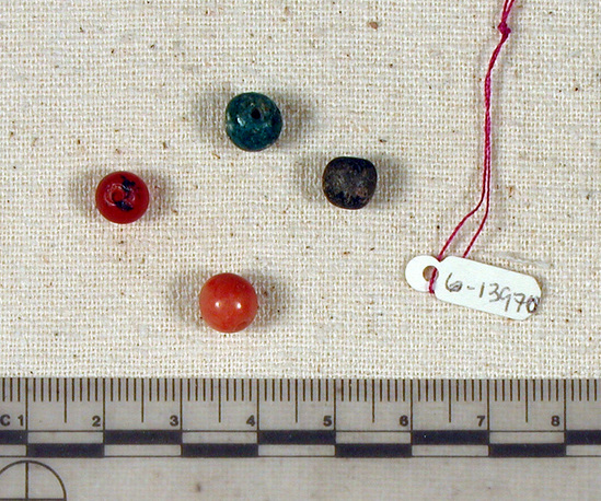 Hearst Museum object titled Beads, accession number 6-13970, described as Beads: 1 pink spherical, 1 green spherical, 1 black spherical, 1 carnelian spherical. [inv.: 2 carnelian, 1 black faience, 1 blue stone]