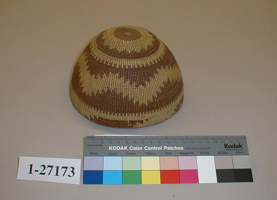 Hearst Museum object titled Hat, accession number 1-27173, described as Twined basket.  Varied bands in brown and white.  Worn and grimy. Hat per Natasha Johnson.