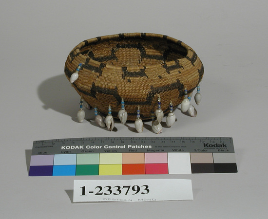 Hearst Museum object 1 of 2 titled Basket, accession number 1-233793, described as Coiled. Fancy basket. Globular. Pendants of blue, yellow and clear glass trade beads, each ending with single olivella shell. 2 dark terrace bands on body, "H"-like design at rim.