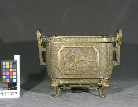 Hearst Museum object titled Urn, accession number 9-17833, described as incense burner; brass, rectangular, phoenix and kirin on opposite sides; four “demon” legs; two rectangular loop handles on two sides, overall relief design