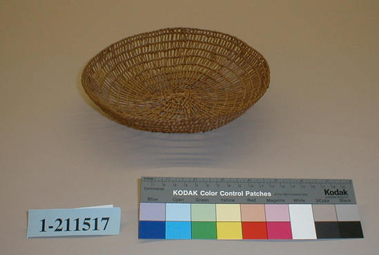 Hearst Museum object 1 of 2 titled Basket, accession number 1-211517, described as Openwork dish-shaped basket.  Tag "NW Calif".  Second tag "Klamath R. Tribes Att.". Per Ralph Shanks:  Twined openwork basket. The basket has a crossed warp starting knot.  The warp and weft material is hazel or willow.  At the start there is some reddish plant material.  The basket is plain twined over primarily one warp, with the rows spaced approximately .5 inch apart. The rim is trimmed.  The basket has an up to the right slant of weft twist and a rightward work direction.  The workface is on the exterior.  The basket is from Northwestern California.