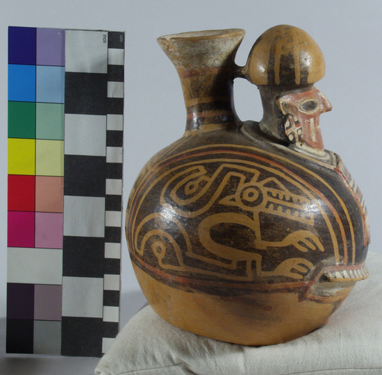 Hearst Museum object 8 of 13 titled Bottle, accession number 16-12114, described as Pottery bottle with flaring spout; effigy of a man with bag slung around neck; red and white slip and resist painted designs. Has been waxed