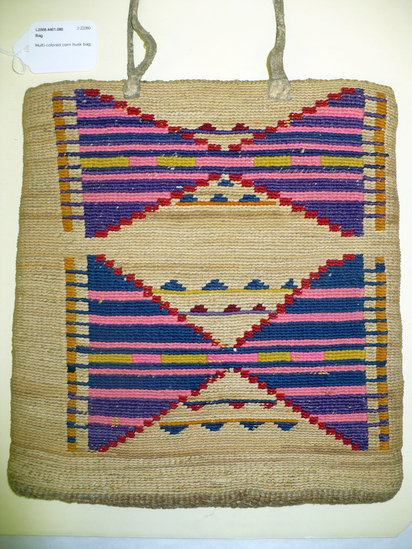 Hearst Museum object 4 of 8 titled Bag, accession number 2-22260, described as Multi-colored corn husk bag; cornhusk and wool overlay in plain twining; geometric designs in colored wool yarn on both faces; 2 rawhide thong handles.