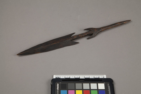 Hearst Museum object titled Spear, accession number 5-17027, described as Carved wooden device with a long, spear point shaped device on one end and a dart-like point with "wings" on the other. Part of the equipment of a man convicted in Southern Province of acting as a witch finder.