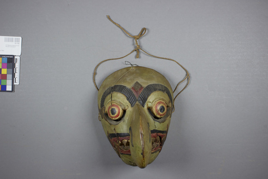 Hearst Museum object 3 of 4 titled Mask, accession number 18-1193, described as Mask, wood, carved and painted; large hook nose and pointed teeth; green, gold, black and red. Used in dance. 18.5 cm.