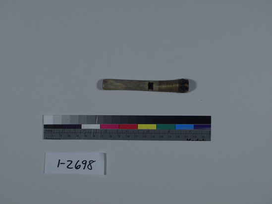 Hearst Museum object 1 of 2 titled Whistle, accession number 1-2698, described as Bird bone. Single slot at center, distal end plugged with pitch and bound with sinew on exterior.