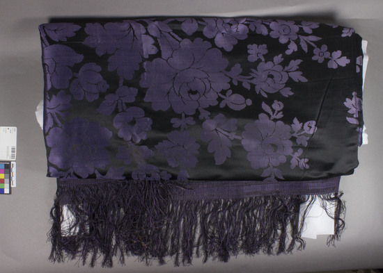 Hearst Museum object titled Shawl, accession number 7-7215, described as Shawl.  Silk.  Satin damask; fringed braid trim.  Black ground, purple designs.  Floral motives.  79 inches by 79 inches, including fringes.