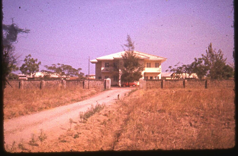 Hearst Museum object titled Color slide, accession number 25-29857, described as 17mm color slide transparency: A yellow house surrounded by a wall in a dry field.