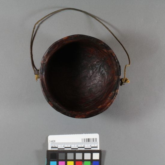 Hearst Museum object titled Bowl, accession number 2-4638, described as Small, round, wooden. Carved burl with 2 handles, in imitation of cast iron round-bottom pot. Rawhide handle.