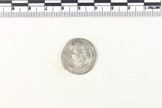 Hearst Museum object 3 of 8 titled Coin: billon denarius, accession number 8-4355, described as Coin; AR; Billon Antoninianus; Roman. 4.66 grams, 23 mm. Elagabalus, 218 AD. Rome, Italy. Obverse: IMP CAES M AVR ANTONINVS AVG, bust r. radiate. Reverse: P M TR P COS P P, Roma seated l.