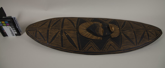 Hearst Museum object titled Shield, accession number TEMP 2018.1412, described as Zambesi (Africa) wood shield, mask at center 27.5" long (mate with TEMP 2018.1429)