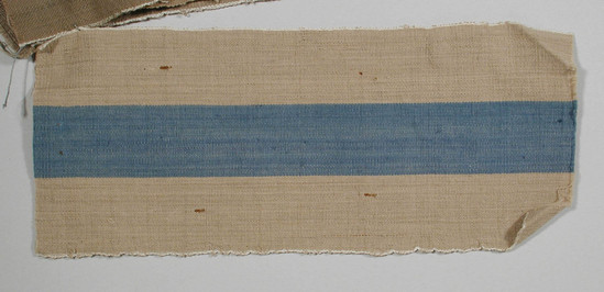 Hearst Museum object titled Textile fragment, accession number 5-11026, described as Textile sample (section of narrow band weaving). Fine beige ground with central 3.1 cm bright blue stripe and white selvages.