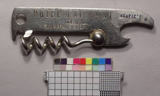 Hearst Museum object titled Corkscrew/bottle opener, accession number 1-216939, described as Corkscrew/cap-lifter combination, pocket type, steel, nickel plated, maximum diameter 9.4 cm. stamped “Hotel Fairmont... San Francisco”. Advertising give-away.