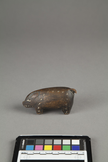 Hearst Museum object 2 of 2 titled Carving of pig, wood, incised, accession number 11-42726, described as Carving of pig, wood, black with white incisions. length - 10.6 cm., height - 5.0 cm.