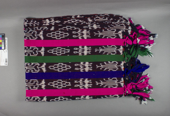 Hearst Museum object titled Shawl, accession number 3-30276, described as RGM ikot and solid striped shawl with knotted fringe; 29 1/2" wide by 6'4" long; solid stripes are bright pink, green and purple; ikot patterns include two women standing together.