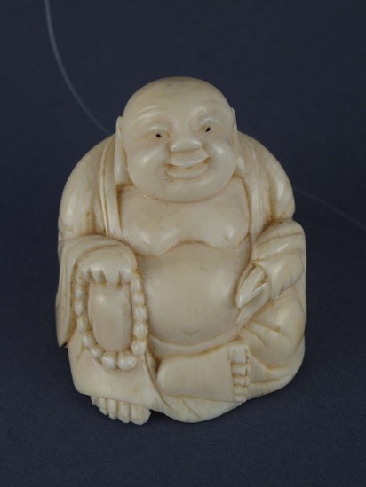 Hearst Museum object 1 of 2 titled Netsuke, accession number 9-7452, described as Netsuke: fat man seated. Buddhist rosary in right hand.