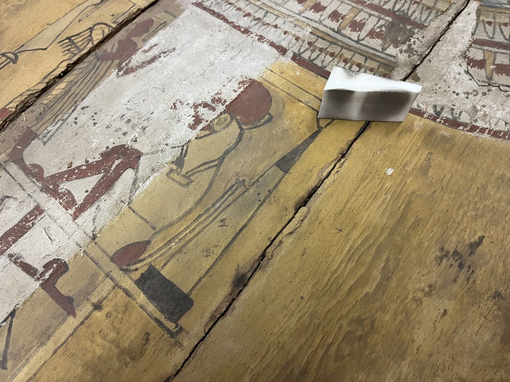 Hearst Museum object 132 of 167 titled Coffin, accession number 6-19912, described as Wooden anthropoid coffin. Inscription running down center of lid. Determined by Kea Johnston to probably be the outer coffin of Iwefaa (6-19928, 12-11039). According to Kea Johnston, "This coffin belonged to a man named Iwefaa, whose name is inserted in the middle of the spells written in the two columns on the front. This coffin is likely the outer coffin for PAHMA 6-19928 based on the similarity of the owner's name, unusual costume, and the paleography of the inscription. Both coffins were purchased on the antiquities market by George Reisner for Phoebe A Hearst. However, stylistically, they are very similar to a set of coffins known to have come from the site of Akhmim, which was excavated in the 1880s by Gaston Maspero, and which has heavily looted for the antiquities market during this decade." "The pectoral vignette between the text and the collar shows the deceased standing before squatting baboon and is the source of our logo. The hieroglyph for 'sky' is above their heads, and the side borders are formed by a pyramid and the symbol for the West.