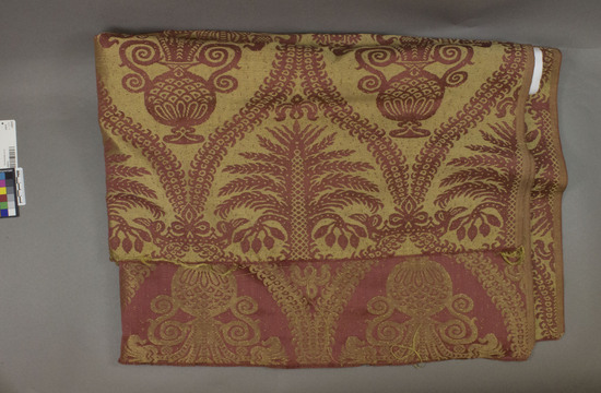 Hearst Museum object titled Textile, accession number 2-62501, described as Strip; cotton, rayon, damask, red ground, light brown and yellow designs, tree, leaf and vase motives, Jacquard looms/ William D. McCann