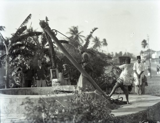 Hearst Museum object titled Black and white negative, accession number 15-32279, described as 4" x 5" Negative. Mombasa. Men lift water from well. Hoefler's original description: "Island of Mombasa. One of the main wells in the native quarters of Mombasa. At this well, men toil throughout the day lifting water in this crude manner from a great depth. There is no pipe system on the island and the water must be carried from wells to the consumers.