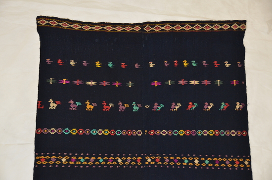 Hearst Museum object titled Huipil, accession number 3-23492, described as Possible tzute; two-width; plain dark blue cotton; rows of free-standing varicolored brocade cotton birds alternate with rows of geometric figures; letter "L" at end of one bird row; center three bands possible flowers; 60.3 x 82.5 cm.