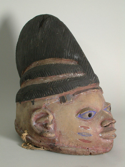 Hearst Museum object 2 of 2 titled Mask, accession number 5-15489, described as mask, wood, handcarved;  representing female head;  stylized facial features in yellow pigment; black hair and headdress in low relief;  H 26.3 cm x W (nose to back of head) ca 31.0 cm.